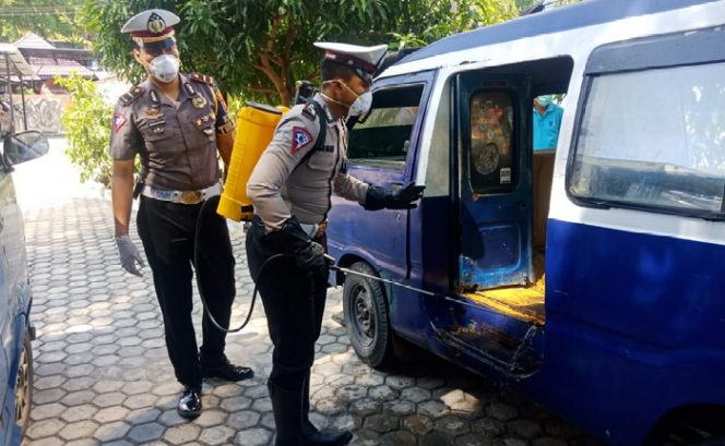 
					Personel Satlantas Polres Karimun menyemprotkan cairan disinfektan ke mobil angkutan umum, Rabu (18/3/2020) siang.