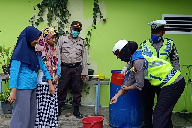 
					Personel Satlantas Polres Karimun memberikan contoh cuci tangan yang benar kepada anak Panti Asuhan Muhammadiyah, Kecamatan Karimun dalam kegiatan Operasi Keselamatan Seligi 2020, Senin (6/4/2020) siang.