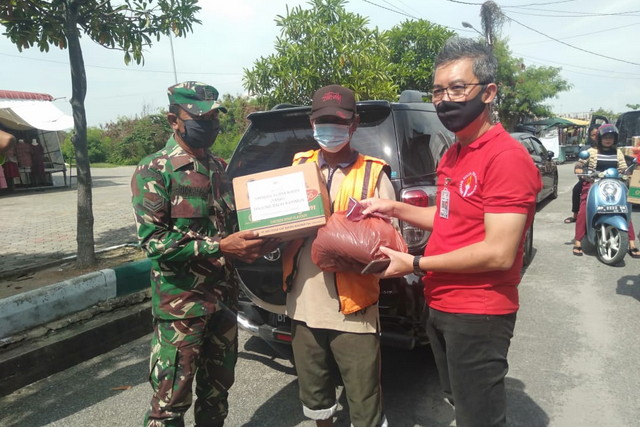 
					Babinsa Sungai Lakam Timur Koramil 01/Balai Kodim 0317/TBK, Sertu Bukhori bersama tiim dari Yayasan Surya Kasih (Yaski) membagikan paket sembako dan masker gratis ke juru parkir, Senin (14/4/2020).