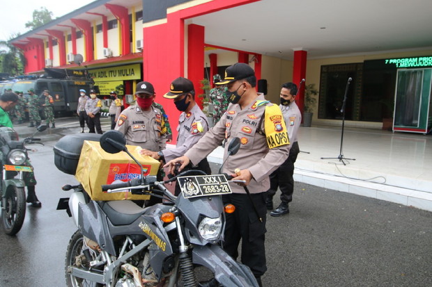 
					Personel TNI-Polri membawa paket sembako untuk dibagikan ke warga kurang mampu di wilayah Kota Batam, Provinsi Kepri, Senin, (27/4/2020). 