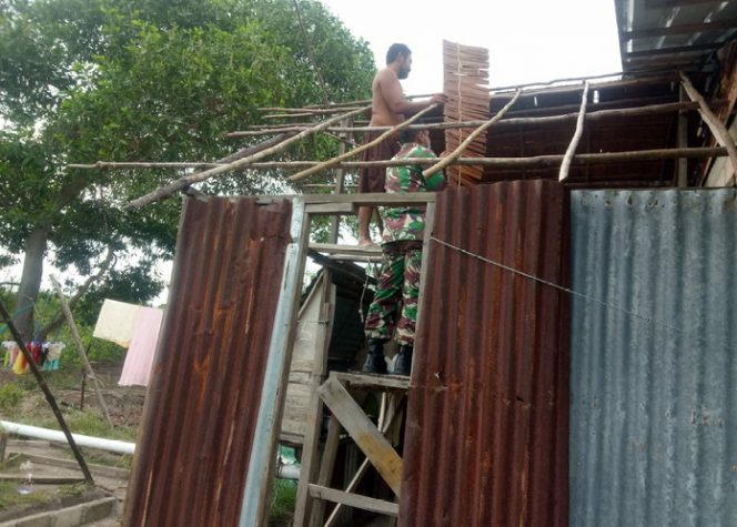 
					Babinsa Desa Pauh Kodim 0317/TBK, Serka M Sinaga sedang membantu memperbaiki dapur rumah warga binaannya, Rabu (12/8/2020).