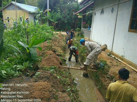 
					Babinsa Kodim 0317/TBK, Sertu Hadi Gunawan bersama warga RT 003 Kelurahan Tebing Kecamatan Tebing, Kabupaten Karimun goro membersihkan parit untuk mengantisipasi banjir, Minggu (13/9/2020).
